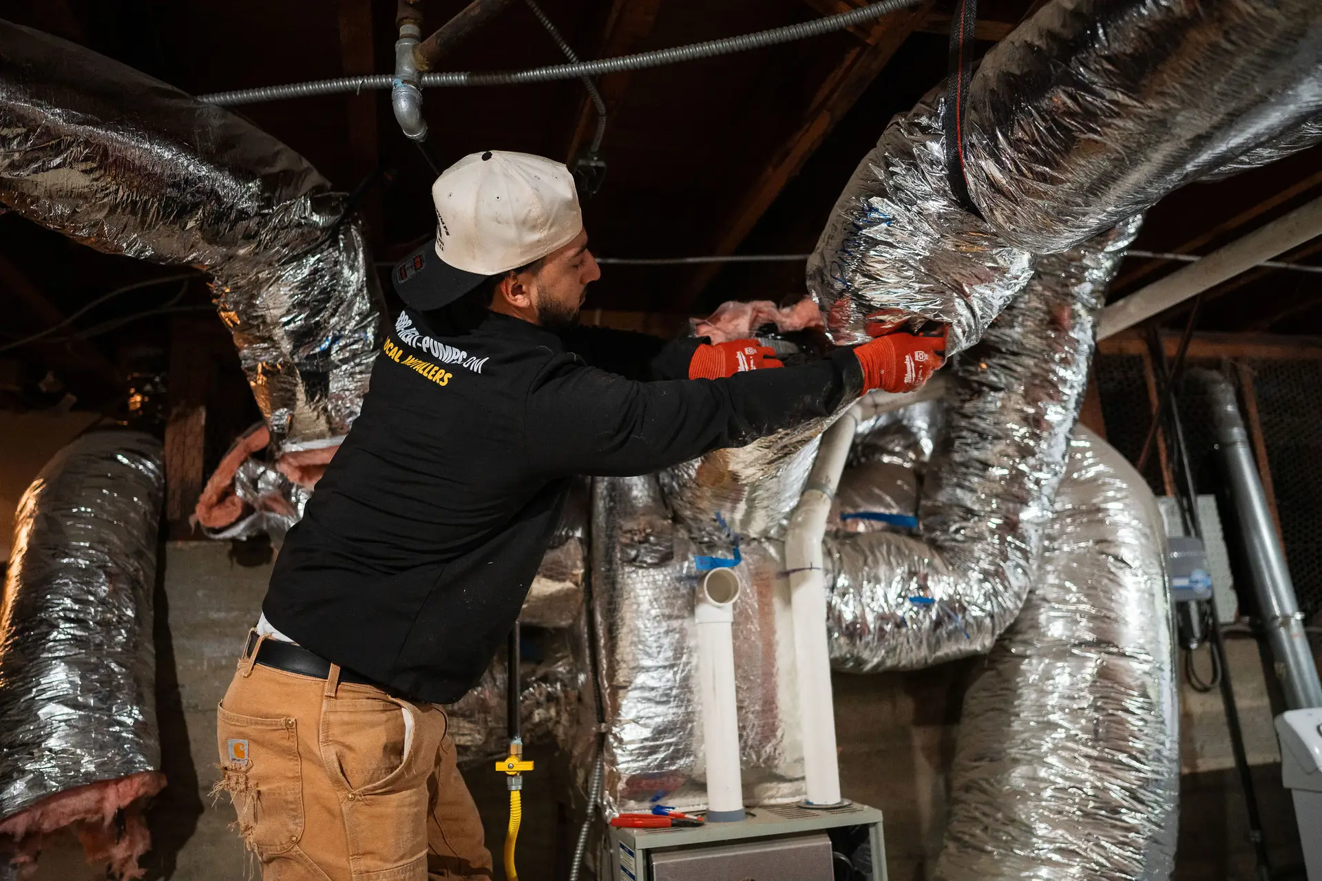 A 1-888-Heat-Pumps technician working on a home heating system